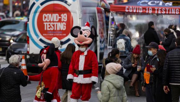 Un hombre disfrazado de Mickey Mouse disfrazado de Papá Noel espera a que la gente le dé propina para fotos cerca de la unidad móvil de prueba de la enfermedad del coronavirus, mientras el espíritu navideño llega a la ciudad de Nueva York, EE.UU. (Foto: REUTERS / Eduardo Munoz).