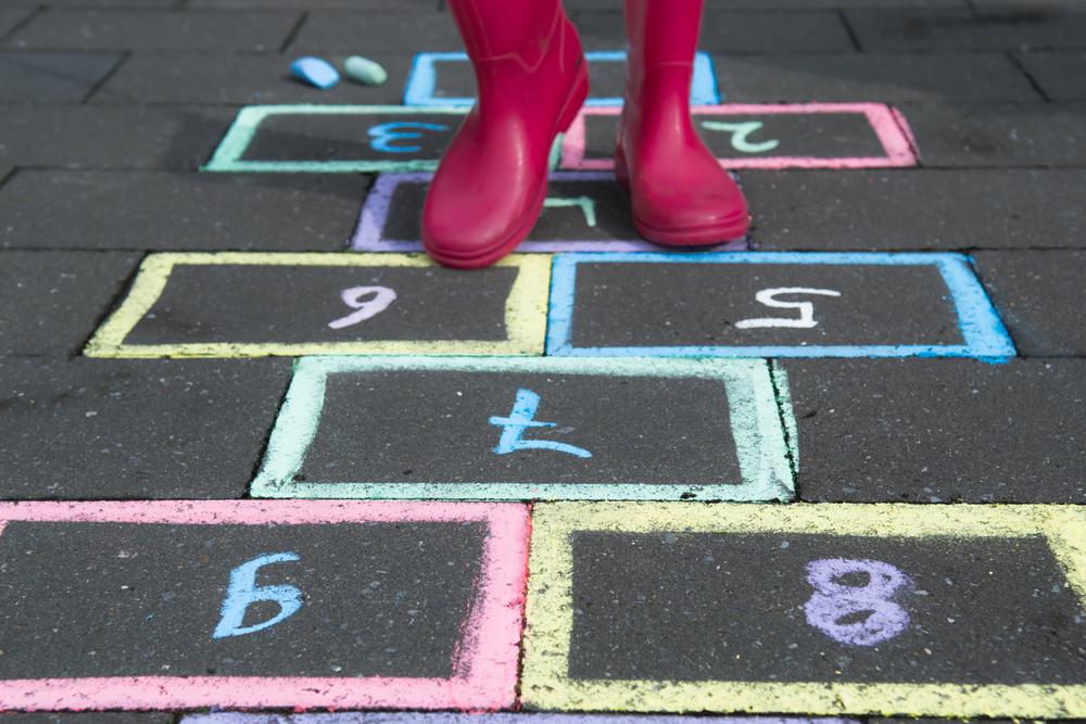 Mundo. Todo lo que necesitabas era una tiza, piedras y unas cuantas personas para jugar. La estrategia del juego era recoger la roca que había sido lanzada a uno de los recuadros pintados en el piso, después de haber saltado encima de todos los demás con una sola pierna. La idea era no caerse.(Foto: Shutterstock)