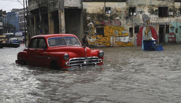 Un automóvil viejo atraviesa una calle inundada en La Habana. (Foto Referencial: AFP / YAMIL LAGE9.