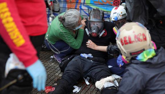 Un voluntario de primeros auxilios herido recibe atención médica durante la manifestación del Primero de Mayo en Santiago, Chile.