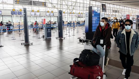 Los pasajeros caminan en el Aeropuerto Internacional Arturo Merino Benítez en Santiago el 1 de abril de 2021, luego de que Chile anunció que cerrará sus fronteras debido a la pandemia de coronavirus. (Martín BERNETTI / AFP).