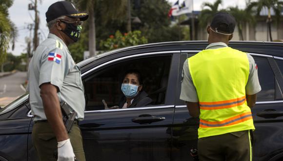Los policías revisan un automóvil en un puesto de control en Santo Domingo, después de que el presidente Danilo Medina decretó el toque de queda como medida preventiva contra la propagación del nuevo coronavirus, COVID-19. (Foto: AFP/Erika Santelices)