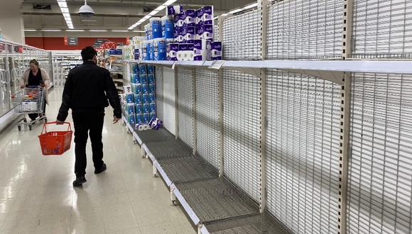 Un comprador pasa por estantes de papel higiénico casi vacíos en un supermercado en Melbourne, la segunda ciudad más grande del país. (Foto de William WEST / AFP)