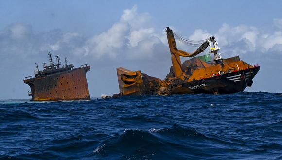 El buque portacontenedores registrado en Singapur MV X-Press Pearl (L) afectado por el fuego se ve hundirse mientras es remolcado lejos de la costa de Colombo, el 2 de junio de 2021. (ISHARA S. KODIKARA / AFP).