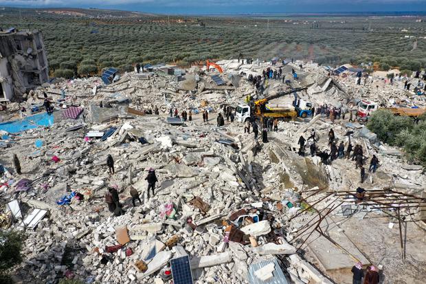 Esta vista aérea muestra a los residentes, ayudados por equipos pesados, buscando víctimas y sobrevivientes entre los escombros de los edificios derrumbados en la aldea de Besnia, cerca de la ciudad de Harim, en Siria. (Foto de Omar HAJ KADOUR / AFP).