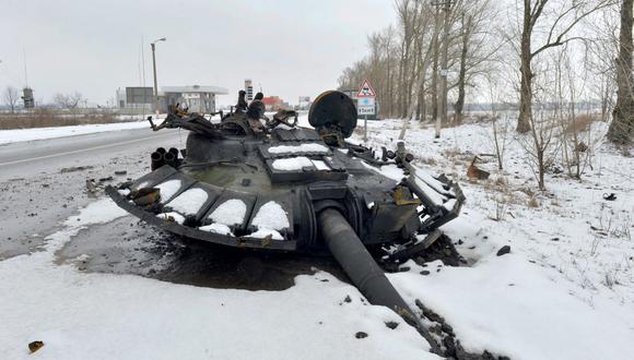 Un fragmento de un tanque ruso destruido se ve al borde de la carretera en las afueras de Kharkiv el 26 de febrero de 2022, luego de la invasión rusa de Ucrania. (SERGEY BOBOK / AFP).