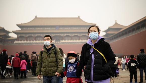 Una familia llega a la entrada de la Ciudad Prohibida en Beijing el 13 de febrero de 2021, durante el Año Nuevo Lunar, que marcó el comienzo del Año del Buey el 12 de febrero. (Foto de NOEL CELIS / AFP).