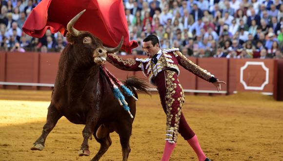 El torero español José María Manzanares realiza un pase a un toro con una muleta durante una corrida de toros en la plaza de toros de La Maestranza en Sevilla el 21 de abril de 2023. (Foto referencial de CRISTINA QUICLER / AFP)