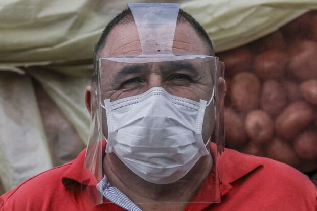 Un hombre con una máscara como medida preventiva contra el nuevo coronavirus posa para una foto en el mercado minorista, que se cerró después de que el alcalde Daniel Quintero anunciara un brote de COVID-19 en Medellín (Foto: Joaquín Sarmiento / AFP)