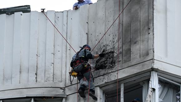 Un especialista inspecciona la fachada dañada de un edificio de apartamentos de varios pisos después de un ataque con drones en Moscú el 30 de mayo de 2023. (Foto de Kirill KUDRYAVTSEV / AFP)