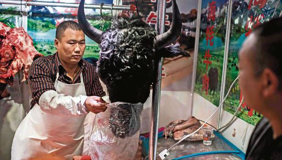 Un carnicero vende una cabeza de yak en un mercado de Beijing. Es una foto tomada a mediados de enero, cuando ya se había desatado la alarma por la aparición del nuevo coronavirus en China. (Foto: AFP)