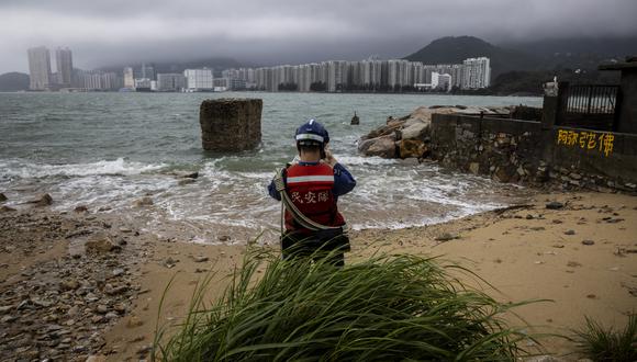 Un miembro del Servicio de Ayuda Civil (CAS) evalúa la marea creciente causada por el súper tifón Saola en una aldea de Lei Yue Mun en Hong Kong el 2 de septiembre de 2023. (Foto de ISAAC LAWRENCE / AFP)