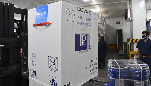 Una caja que contiene vacunas  Covishield desarrolladas por el Serum Institute of India (SII)  es descargada en el aeropuerto de Bombay el 24 de febrero de 2021, como parte del esquema Covax. (Foto de INDRANIL MUKHERJEE / AFP).