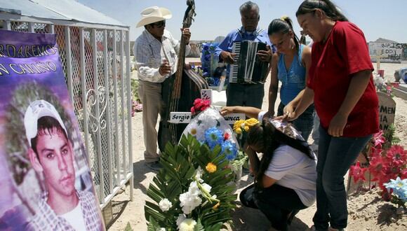 Los familiares consuelan a María Guadalupe Guereca mientras llora en la tumba de su hijo en Ciudad Juárez, México, en 2012 (Foto: EFE)