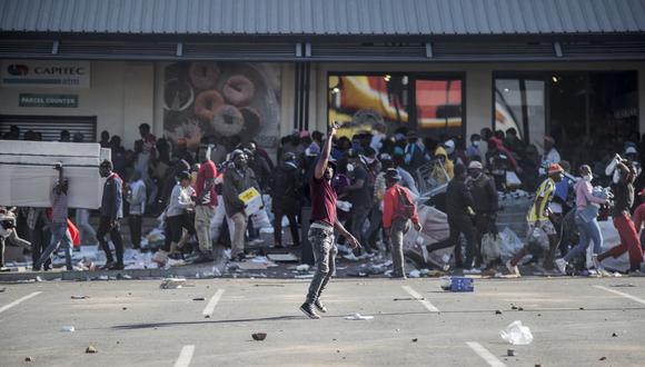 La gente saquea el centro comercial Jabulani Mall en Soweto, Sudáfrica, el 12 de julio de 2021. (Foto de LUCA SOLA / AFP).