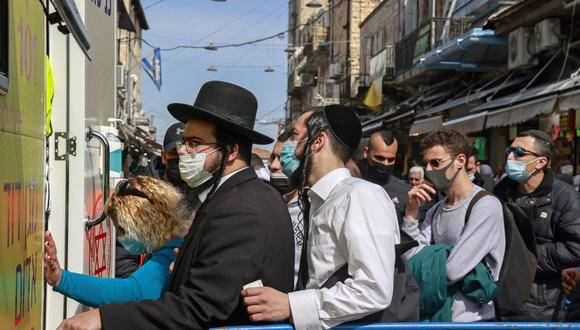 Israel: Personas hacen cola para vacunarse contra el coronavirus frente a una clínica móvil estacionada en el mercado Mahane Yehuda en Jerusalén el 22 de febrero de 2021. (Foto de MENAHEM KAHANA / AFP).