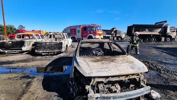 Un bombero camina junto a algunos de los vehículos quemados en Los Álamos, Región de Arauco, sur de Chile el 27 de abril de 2022. (Foto referencial de Manuel ARENEDA / ATON CHILE / AFP)