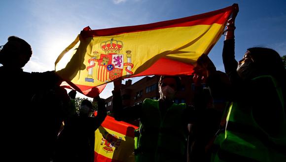En esta foto de archivo tomada el 7 de abril de 2021, los partidarios de Vox sostienen una bandera de España durante la presentación del candidato para las elecciones regionales de Madrid en el suburbio de Vallecas. (JAVIER SORIANO / AFP).