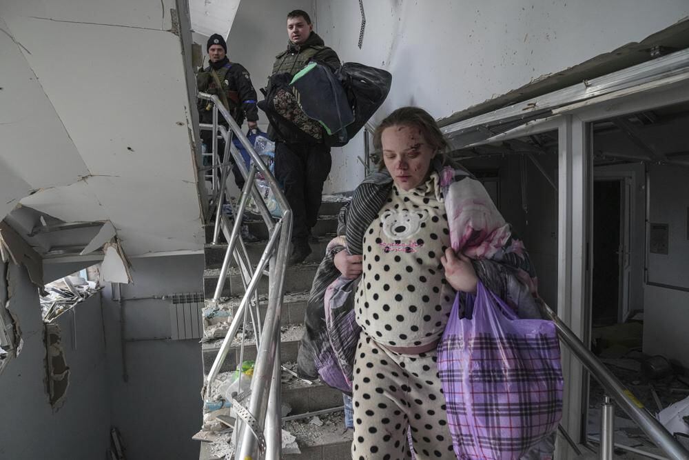 Mariana Vishegirskaya walks down the rubble-strewn stairs at the hospital that was bombed.  She gave birth and managed to survive with her baby.  (AP Photo/Evgeny Maloletka)