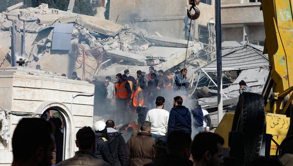 Personas y rescatistas se reúnen frente a un edificio destruido en un ataque israelí en Damasco el 20 de enero de 2024. (Foto de Louai Beshara / AFP)