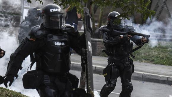 Miembros del Escuadrón Móvil Antidisturbios (ESMAD) disparan gases lacrimógenos durante una protesta de estudiantes en Medellín, Colombia. (Foto: JOAQUIN SARMIENTO / AFP).