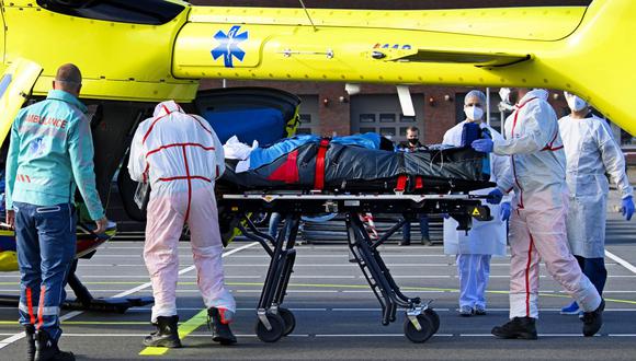 Personal médico lleve en camilla a un paciente infectado con coronavirus covid-19 para una evacuación en helicóptero desde el Hospital Flevo en Almere, a Munster, Alemania, el 23 de octubre de 2020. (Foto de Olaf Kraak / ANP / AFP).
