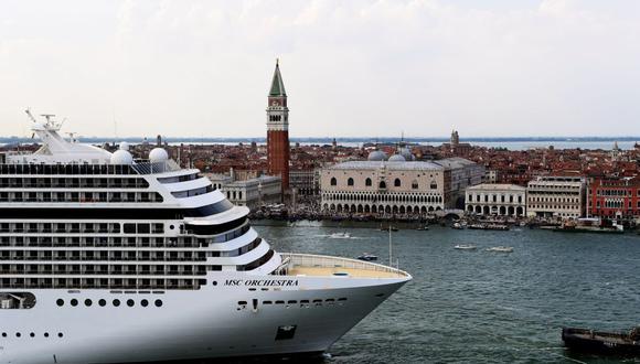 Remolcadores escoltan al crucero MSC Orchestra en Venecia, Italia, el 5 de junio de 2021, en plena pandemia de coronavirus. (Foto referencial, MIGUEL MEDINA / AFP).