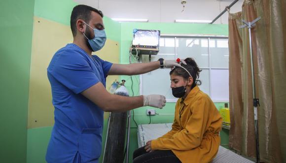 Un trabajador de la salud toma una muestra de hisopado nasal de un paciente para realizar la prueba de Covid-19 en el centro de detección respiratoria en el Hospital Shifa en la ciudad de Gaza, Gaza. (Foto: Ahmad Salem / Bloomberg).