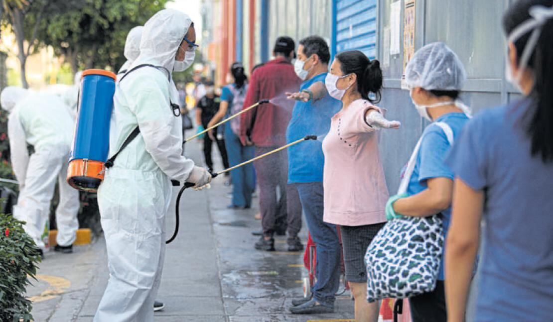 El público es desinfectado al ingreso del mercado de Breña. Formaron cola para evitar aglomeraciones. (Foto: Britanie Arroyo)