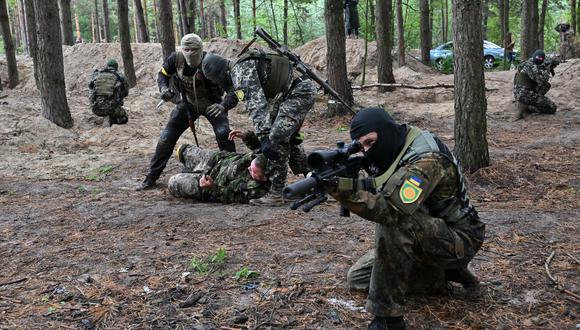 Combatientes de la unidad de defensa territorial, una fuerza de apoyo al ejército regular ucraniano, participan en un ejercicio como parte de las clases regulares de tácticas de combate, el 13 de julio de 2022. (Foto de Serguéi SUPINSKY / AFP)