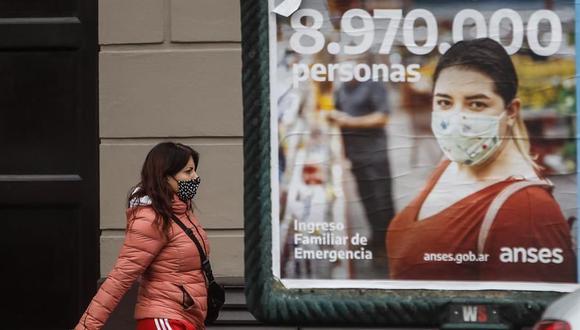 Una mujer camina frente a un afiche publicitario este lunes, en Buenos Aires. Argentina inicia una nueva extensión de la cuarentena que llevará al país austral a completar seis meses de confinamiento, en medio del constante aumento de casos de coronavirus. (EFE/Juan Ignacio Roncoroni).