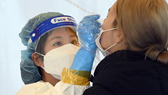 Personal médico toma una muestra nasal para una prueba de coronavirus covid-19 en Seúl el 14 de diciembre de 2021. (Jung Yeon-je / AFP).