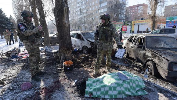 Agentes del orden fotografían el cuerpo de una persona que murió como resultado de un ataque con misiles en Donetsk el 21 de enero de 2024. (Foto de STRINGER / AFP)