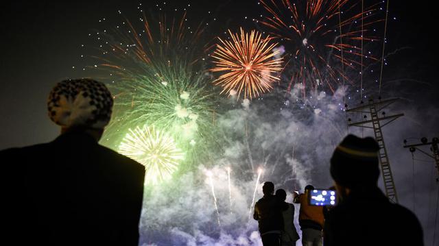 La gente de Pakistán mira los fuegos artificiales como parte de las celebraciones de Año Nuevo en Rawalpindi. (Foto: AFP).