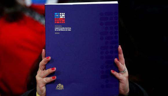 Una integrante de la Convención Constituyente de Chile sostiene el borrador final de la propuesta de nueva Constitución, el 4 de julio de 2022. (JAVIER TORRES / AFP).
