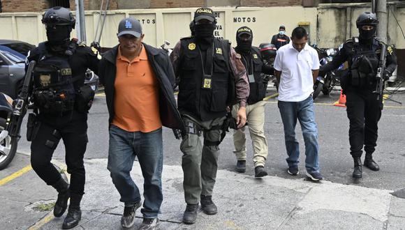 Miguel Felipe Francisco (2-L) y Felipe Diego Alonzo (2-R) son escoltados por la policía después de ser arrestados, afuera del Palacio de Justicia en la Ciudad de Guatemala, el 2 de agosto de 2022. (Foto de Johan ORDONEZ / AFP)