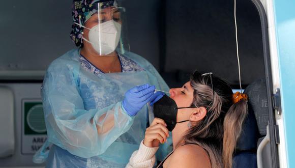 Una trabajadora de la salud toma una muestra nasal de una mujer para una prueba de coronavirus COVID-19 en Santiago de Chile, el 26 de enero de 2022. (JAVIER TORRES / AFP).
