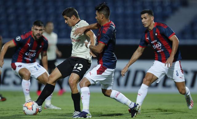 Defender Aldo Corzo, center left, of Peru's Universitario fights for the ball with defender Santiago Arzamedia, center right, of Paraguay's Cerro Porteno during a Copa Libertadores soccer match at the Pablo Rojas stadium in Asuncion, Paraguay, Wednesday, Feb. 12, 2020. (AP Photo/Jorge Saenz)