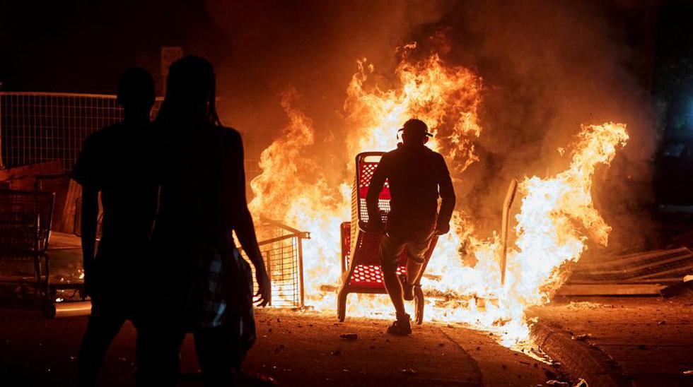 Los manifestantes se reúnen para quemar los carros de compras cerca del tercer recinto de la Policía de Minneapolis después de que un policía blanco fue atrapado en un video de un espectador presionando su rodilla en el cuello de George Floyd, quien luego murió en un hospital, en Minneapolis. (Foto: REUTERS / Adam Bettcher).