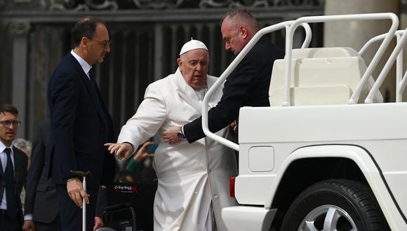 Ayudan al papa Francisco a subir al coche del papamóvil cuando sale el 29 de marzo de 2023 al final de la audiencia general semanal en la plaza de San Pedro en el Vaticano. (Foto de Vincenzo PINTO / AFP)