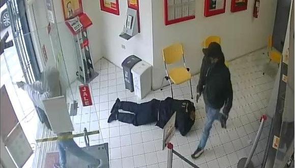 Uno de los delincuentes encapuchados en pleno asalto a la agencia bancaria fue captado por las cámaras del recinto. (Captura de video)