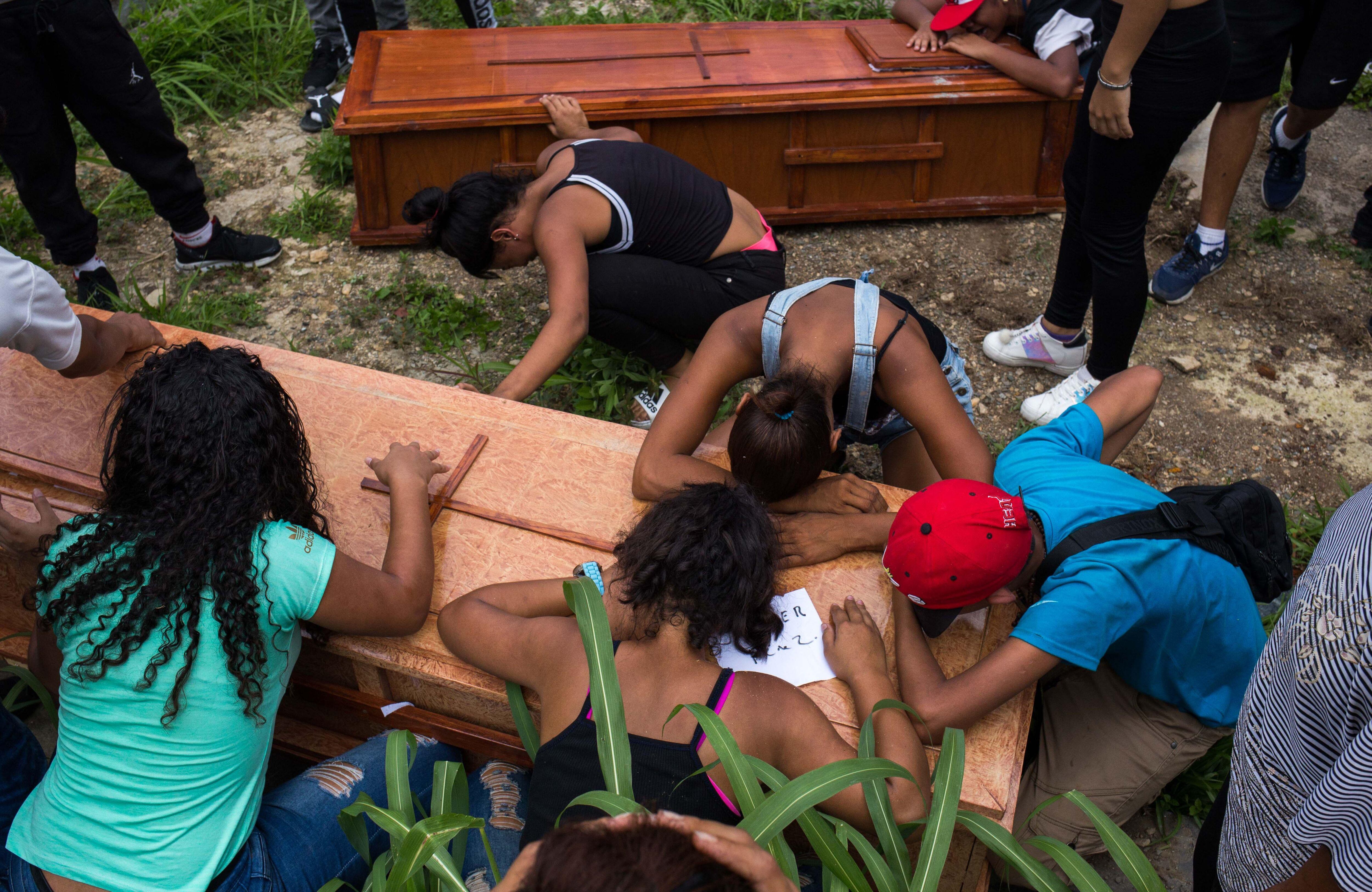Familiares y amigos lloran en el entierro de Johander Perez y Wuilkerman Ruiz en el Cementerio General de Caracas. Ambos fueron supuestamente asesinados por las FAES. (AFP).
