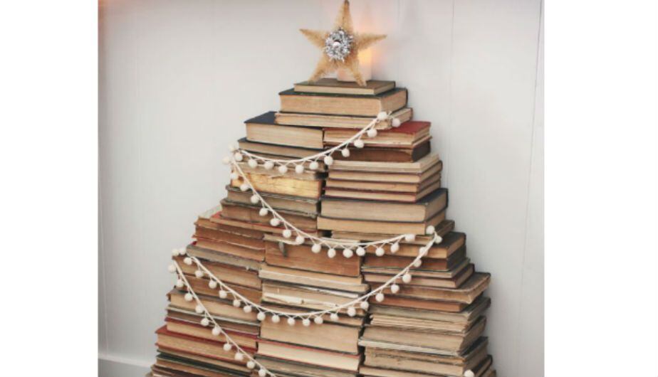 Si eres un amante de los libros, puedes apilarlos en forma de árbol navideño para darle un toque más intelectual a tu navidad. Foto: Pinterest / Eclectically Vintage