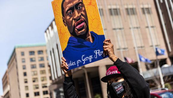 Un manifestante sostiene un cartel en honor a George Floyd frente al Centro de Gobierno del Condado de Hennepin el 28 de marzo de 2021, en Minneapolis, Minnesota. (Foto de Kerem Yucel / AFP).