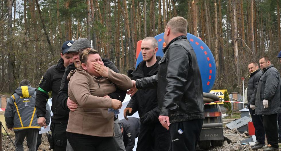 Una madre ucraniana reacciona después de que se descubriera el cuerpo de su hijo en una alcantarilla de una gasolinera en las afueras de la aldea de Buzova, al oeste de Kiev, el 10 de abril de 2022. (Serguéi SUPINSKY / AFP).