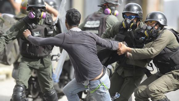 La Guardia Nacional Bolivariana de Venezuela trata de arrestar a un joven durante una protesta de médicos en Caracas. (AFP).