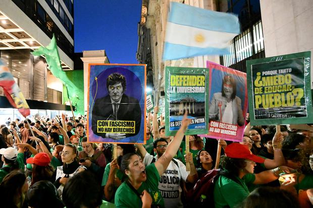 Manifestantes sostienen carteles durante una marcha de protesta por el ajuste presupuestario de las universidades públicas, en Buenos Aires, el 23 de abril de 2024. (Foto de Luis ROBAYO / AFP)