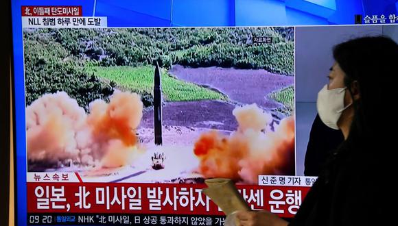 Una mujer pasa frente a una pantalla de televisión que muestra una transmisión de noticias con imágenes de archivo de una prueba de misiles de Corea del Norte, en una estación de tren en Seúl el 3 de noviembre de 2022. (Jung Yeon-je / AFP).