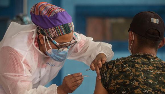 Un integrante del servicio de salud mientras vacuna contra la covid-19 a un integrante de las brigadas departamentales al Servicio de Sanidad Militar y al Batallón Humanitario y de Rescate en Ciudad de Guatemala. (Foto: EFE/Esteban Biba).