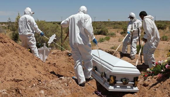 Trabajadores de un cementerio entierran el ataúd de una mujer en un área del panteón municipal de San Rafael designado para víctimas del nuevo coronavirus, COVID-19, en Ciudad Juárez, Estado de Chihuahua, México. (Foto de Herika MARTINEZ / AFP).